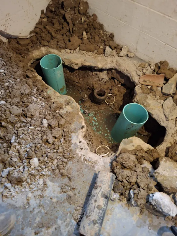 New PVC risers set in the excavated floor cut for a backflow preventer