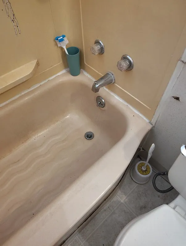 The same bathtub after the blockage was cleared and the water drained away