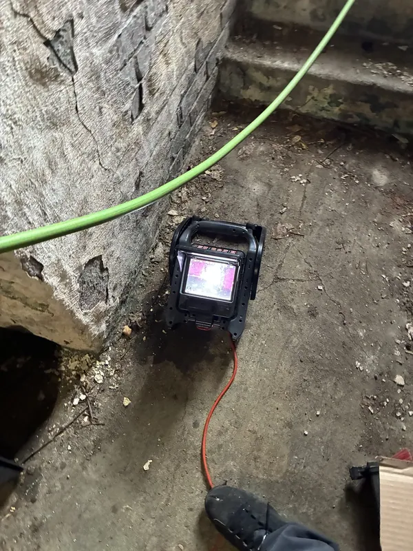 A sewer inspection camera reel and monitor set up at an exterior cleanout