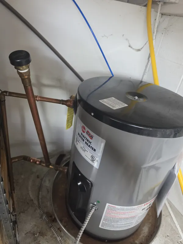 A new small electric water heater installed with fresh copper connections