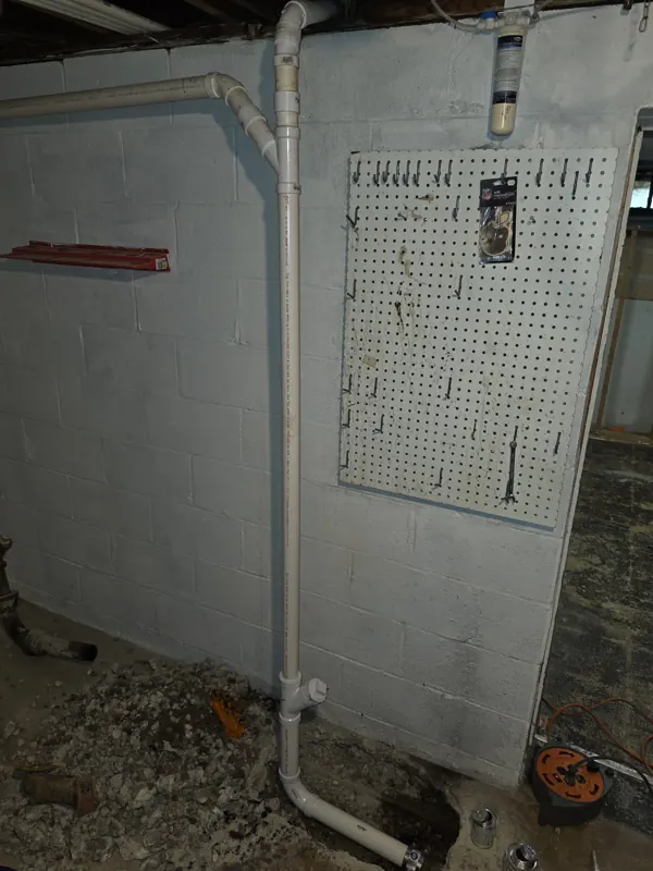 New PVC drain piping with a cleanout run along the same basement wall