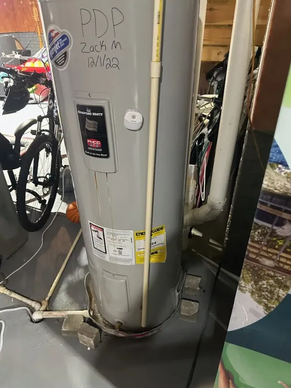 A residential water heater installed in a basement utility area