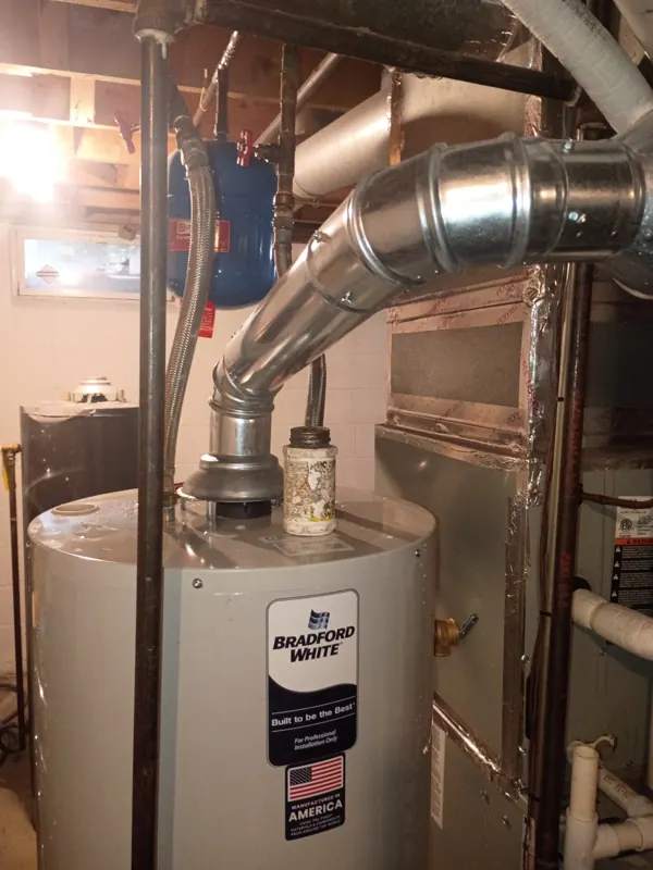 A new gas water heater with new venting and water connections in the same basement