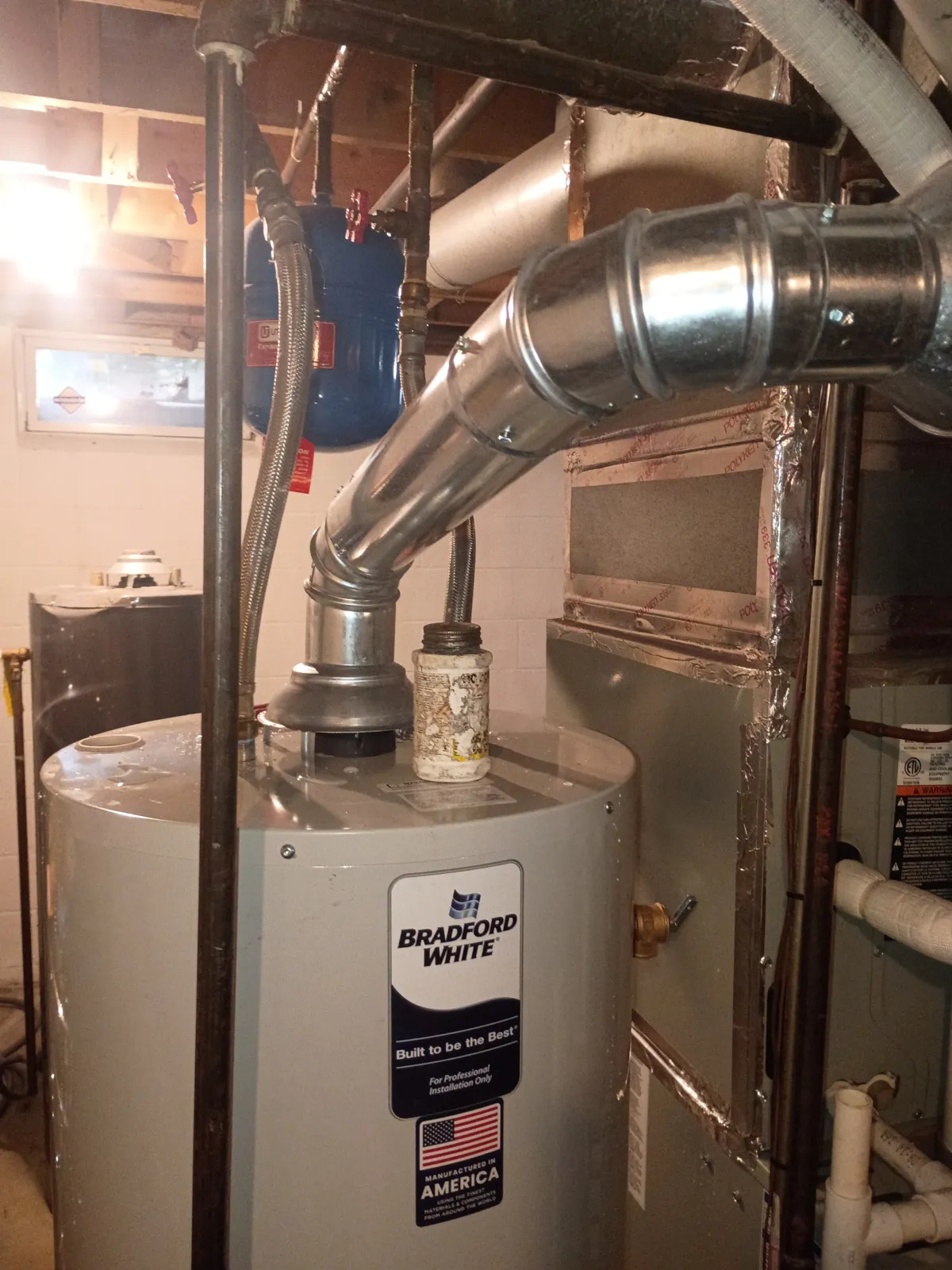A new gas water heater with new venting and water connections in the same basement