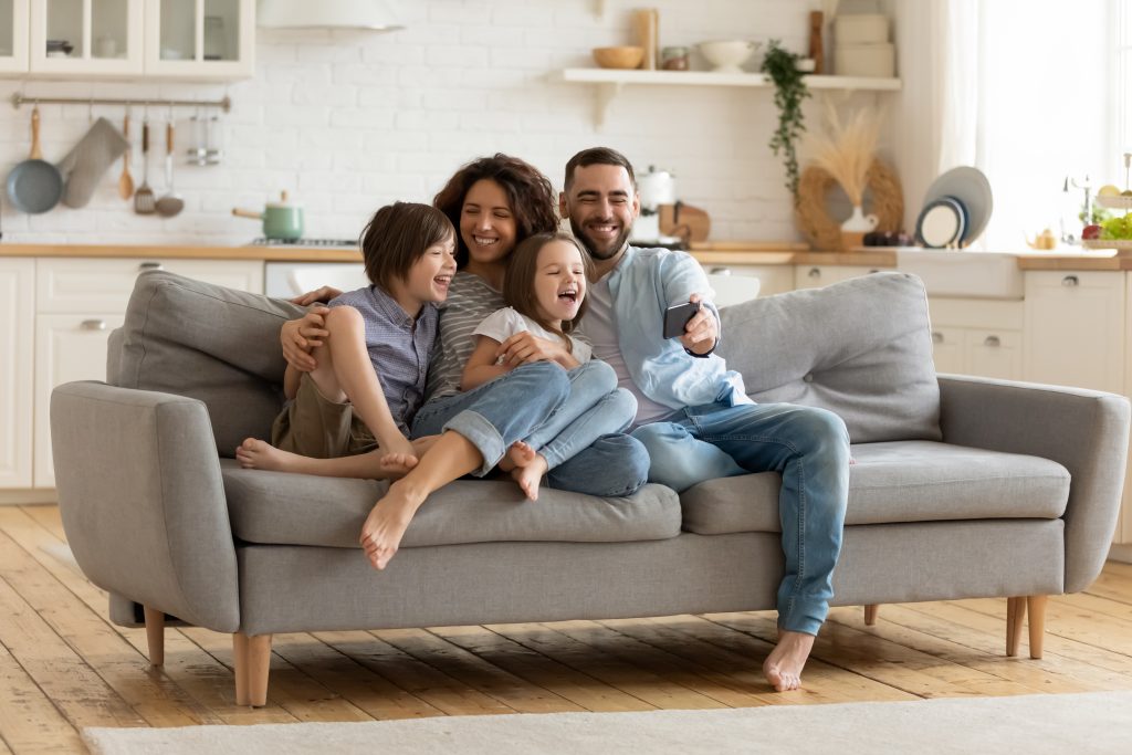 Happy family sitting together on a couch in a bright home