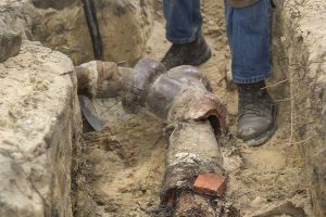 Exposed underground sewer pipe during excavation repair